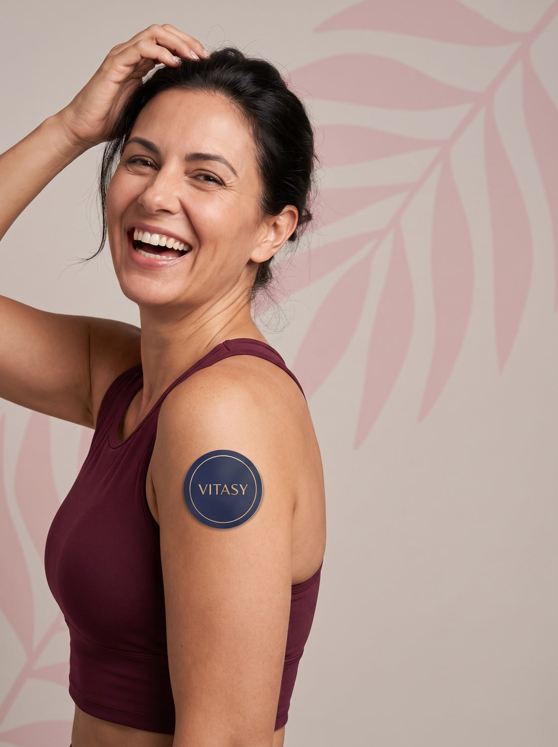 Smiling woman with a Vitasy patch on her upper arm