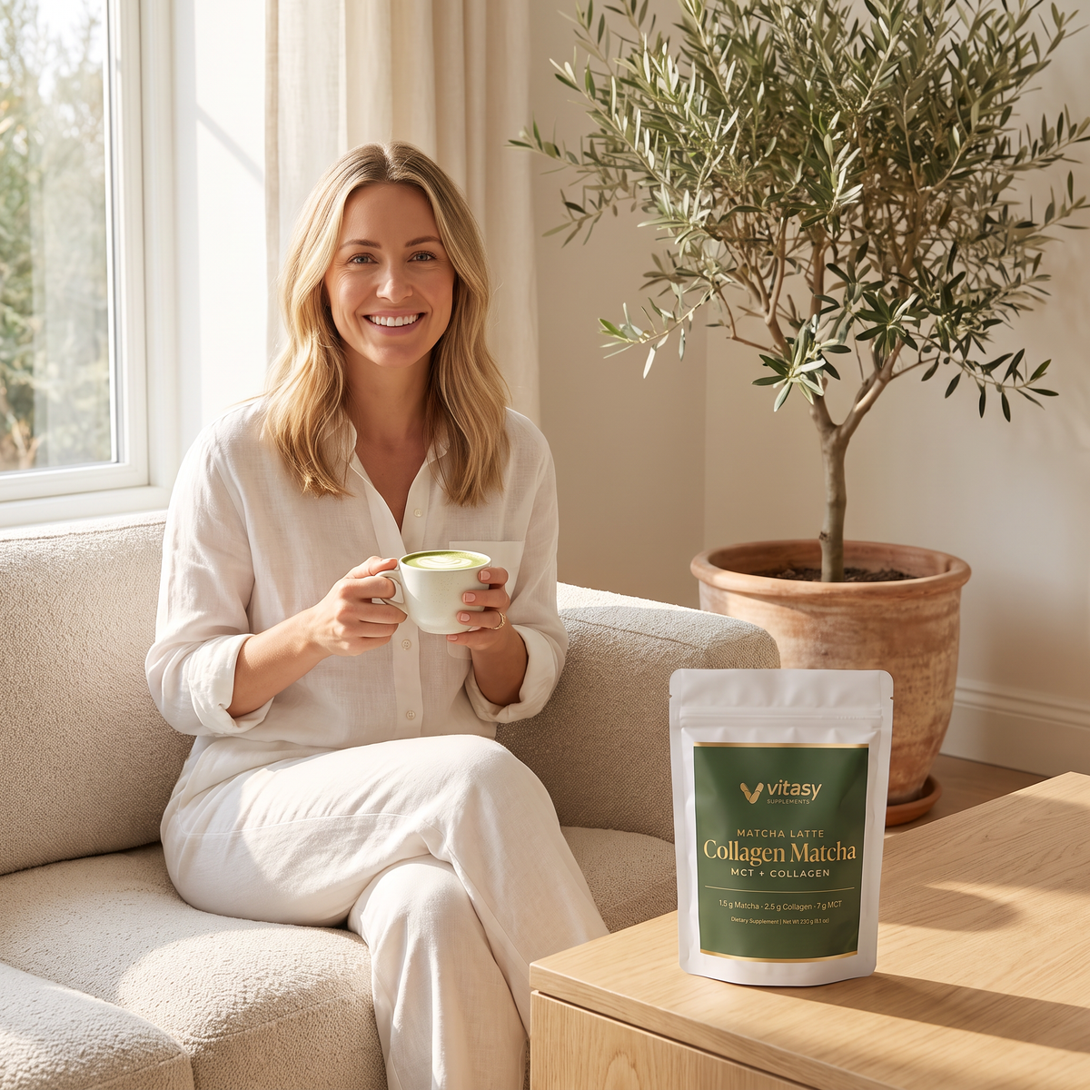Woman enjoying a matcha latte at home next to Vitasy Collagen Matcha
