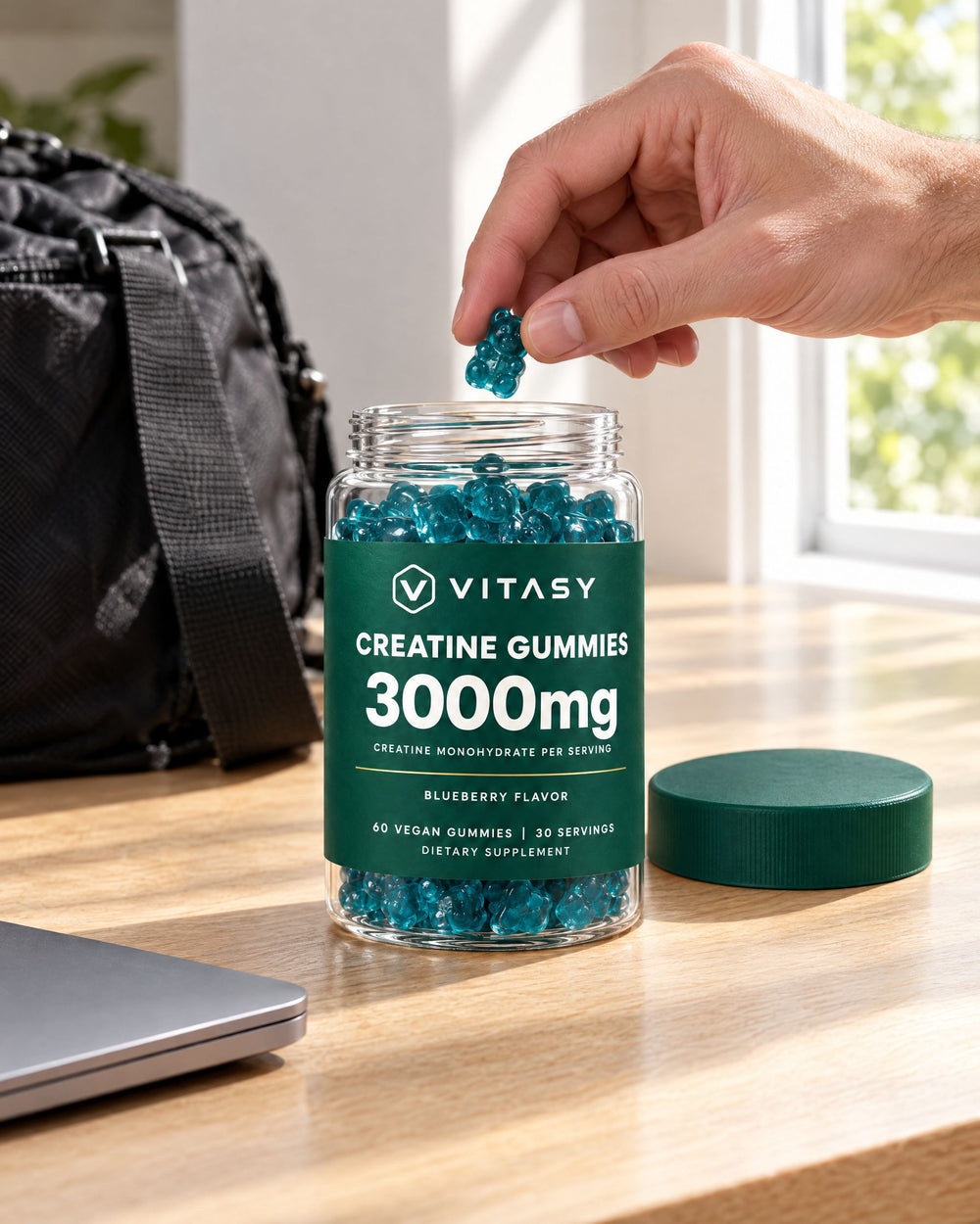 Taking a creatine gummy from the jar at a desk