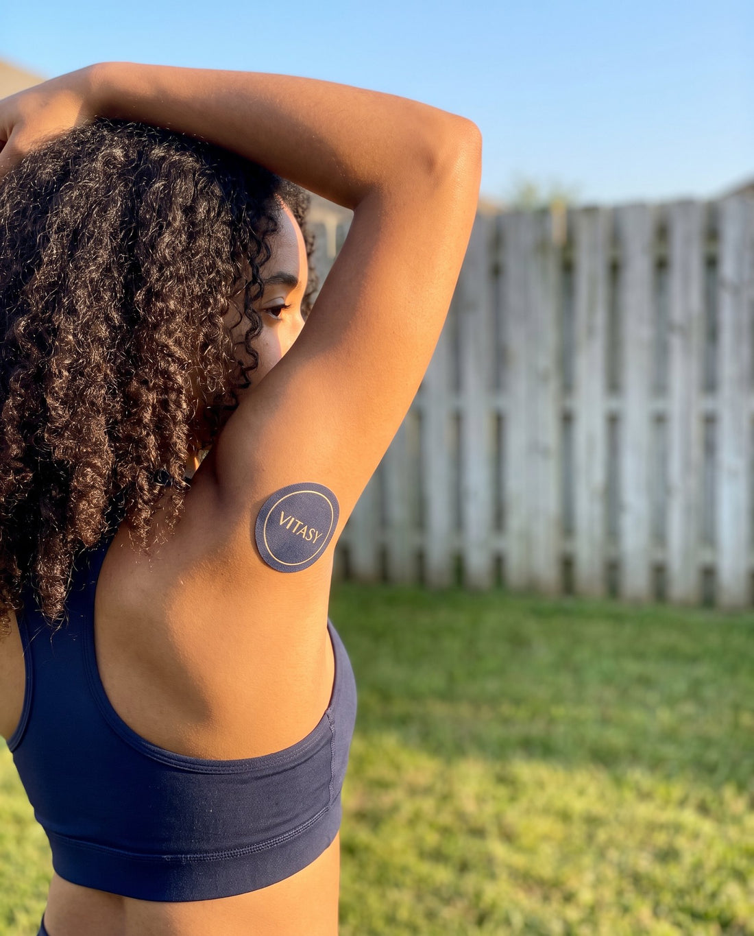 Woman outdoors wearing a Vitasy energy patch on her upper arm