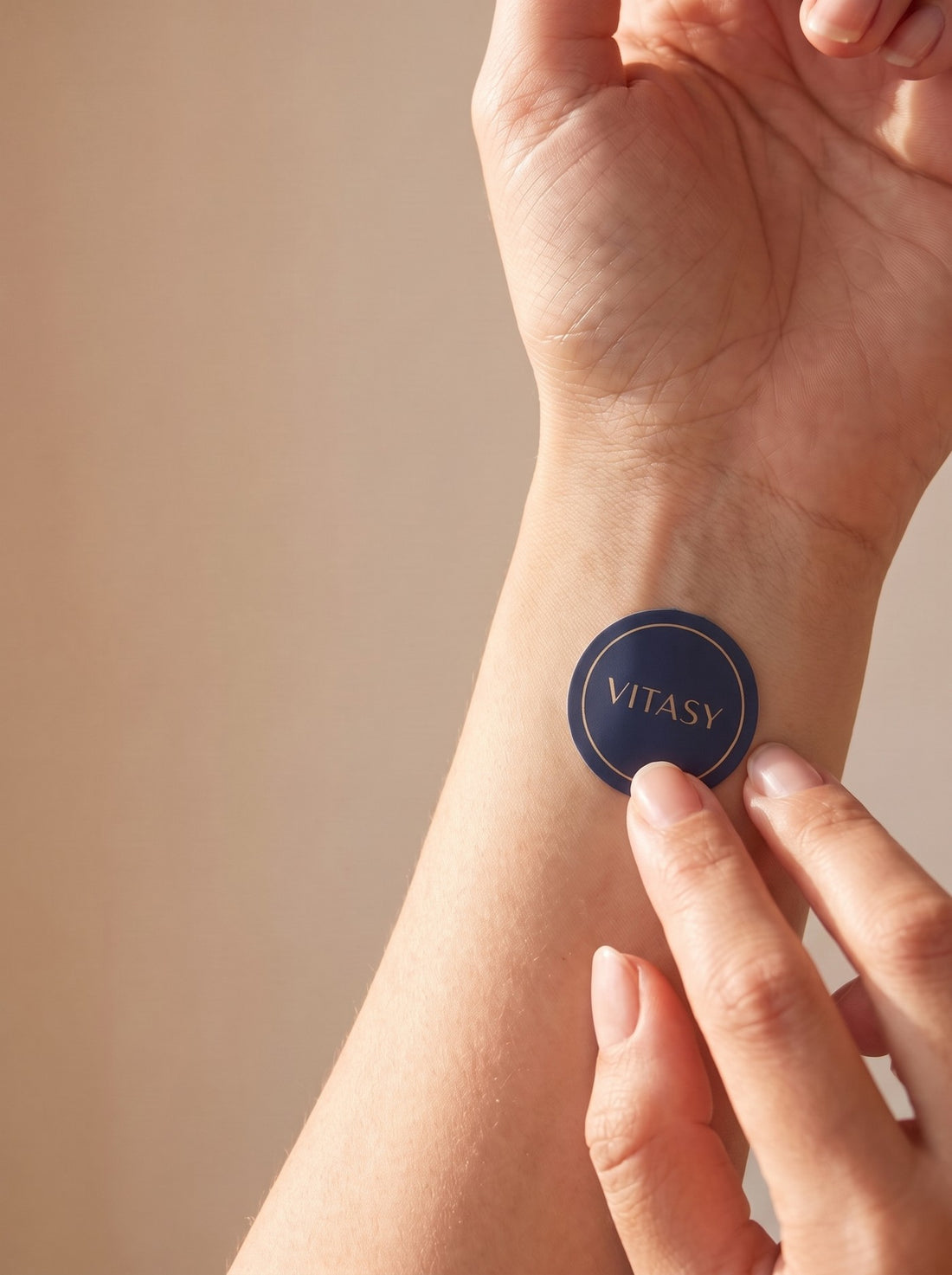 Applying a Vitasy energy patch to the inner wrist