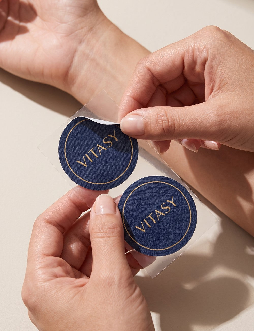 Hand peeling a Vitasy patch from its clear backing