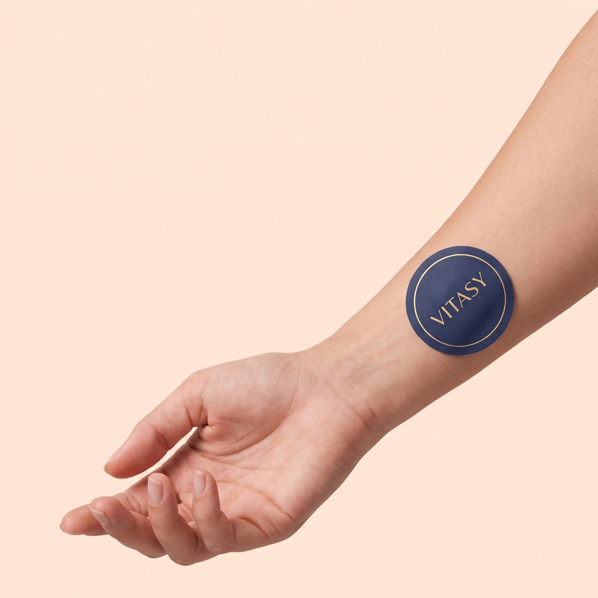 Round Vitasy patch worn on the inner forearm