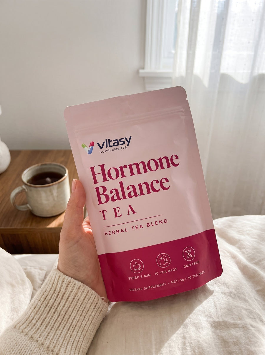 Holding the Vitasy Hormone Balance Tea pouch in bed