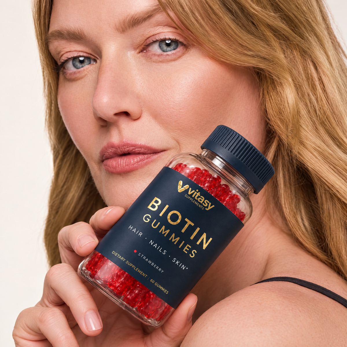 Woman holding a bottle of Vitasy Biotin Gummies Strawberry