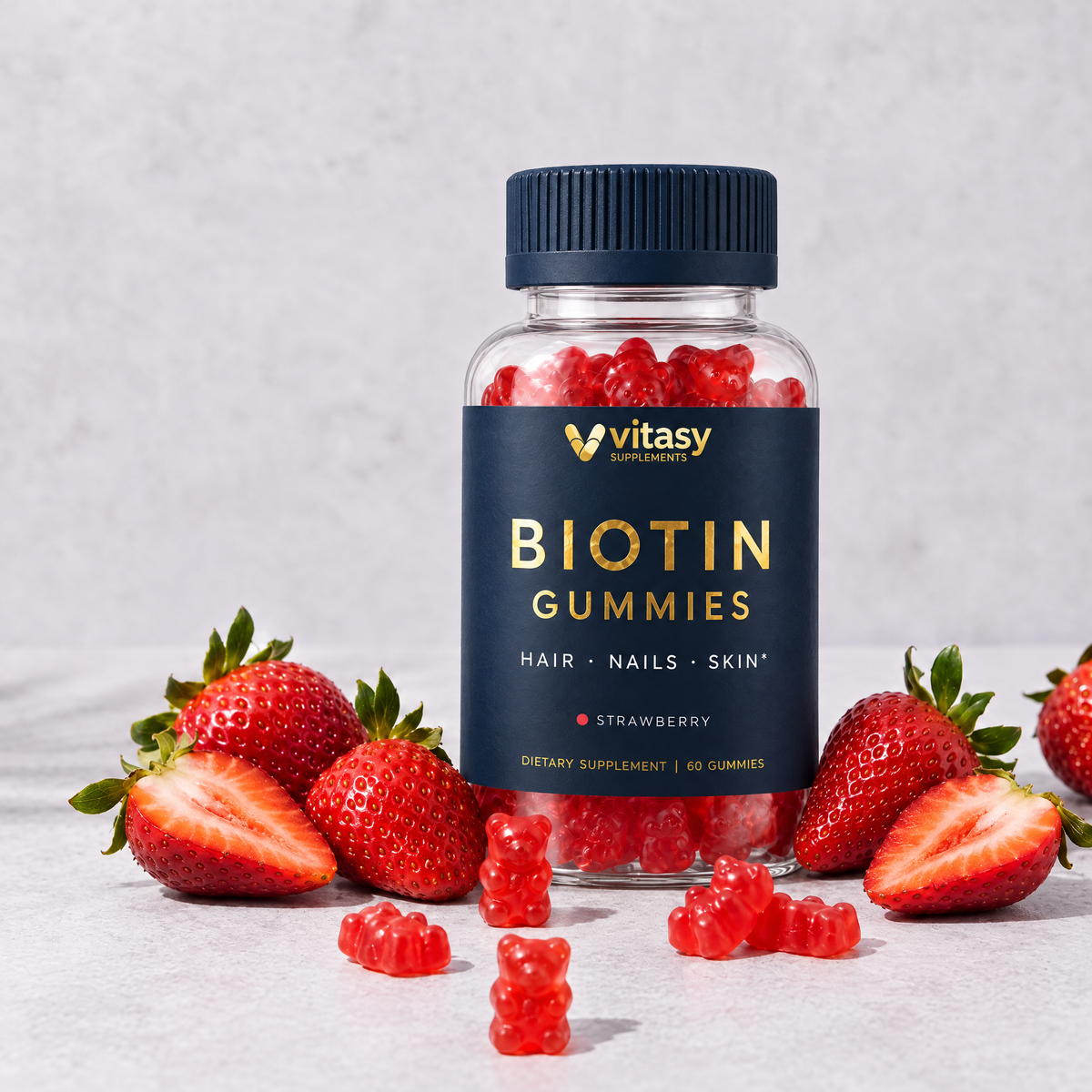 Vitasy Biotin Gummies Strawberry bottle standing on stone with fresh strawberries and gummy bears