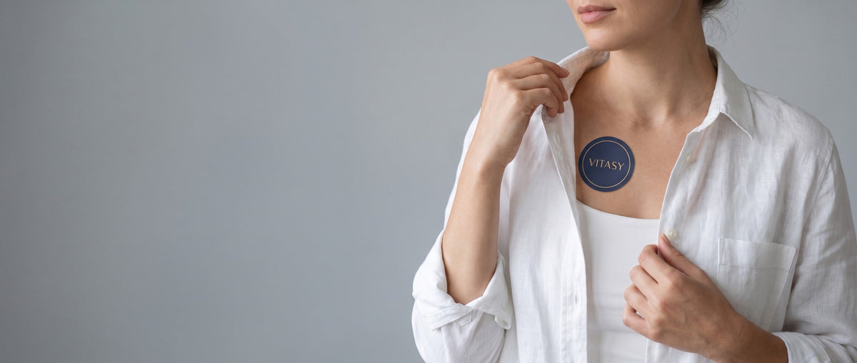 Woman in a white shirt with a Vitasy patch below her collarbone
