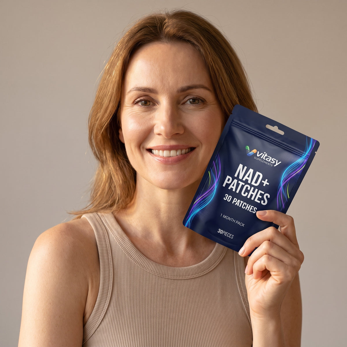 Smiling woman holding a pouch of Vitasy NAD+ Patches