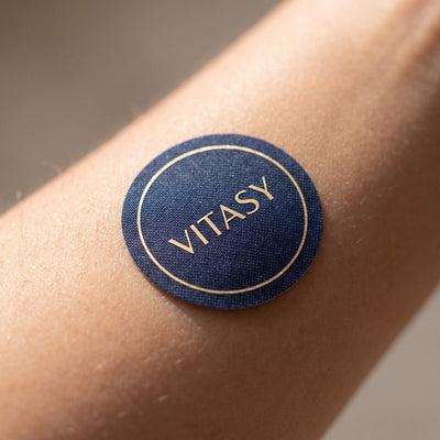 Close-up of a navy Vitasy patch on the forearm