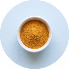 Golden CoQ10 powder in a ceramic bowl