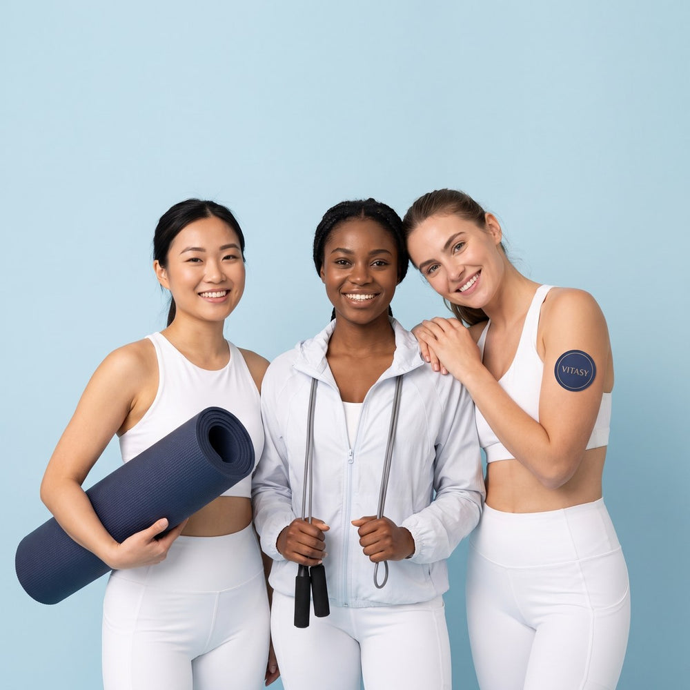 Three women in white activewear, one with a Vitasy patch on her upper arm