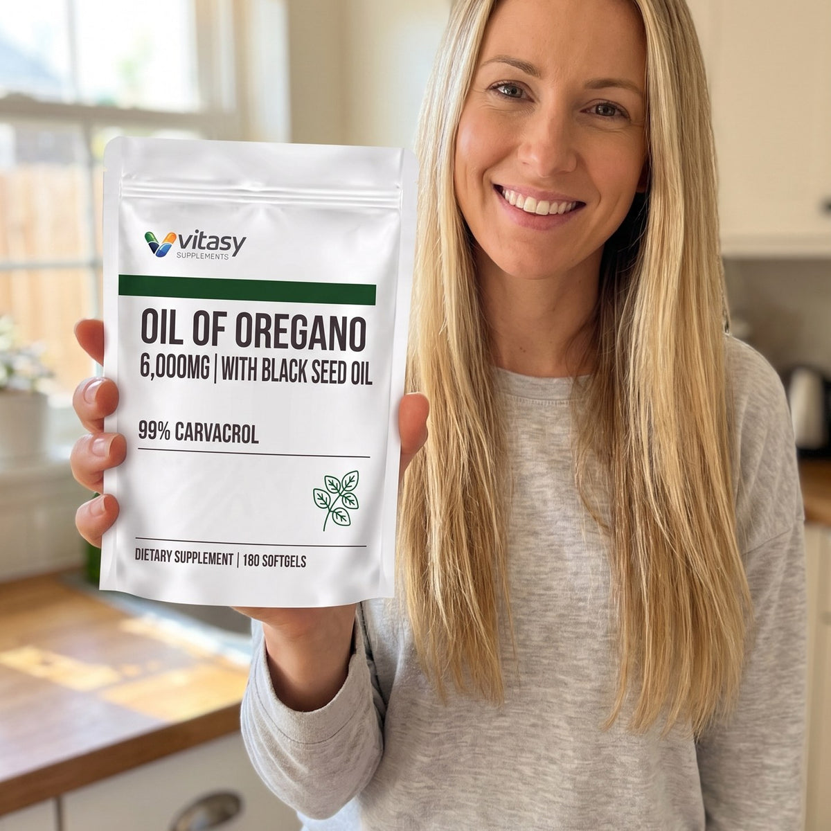 Smiling woman holding the Vitasy Oil of Oregano pouch