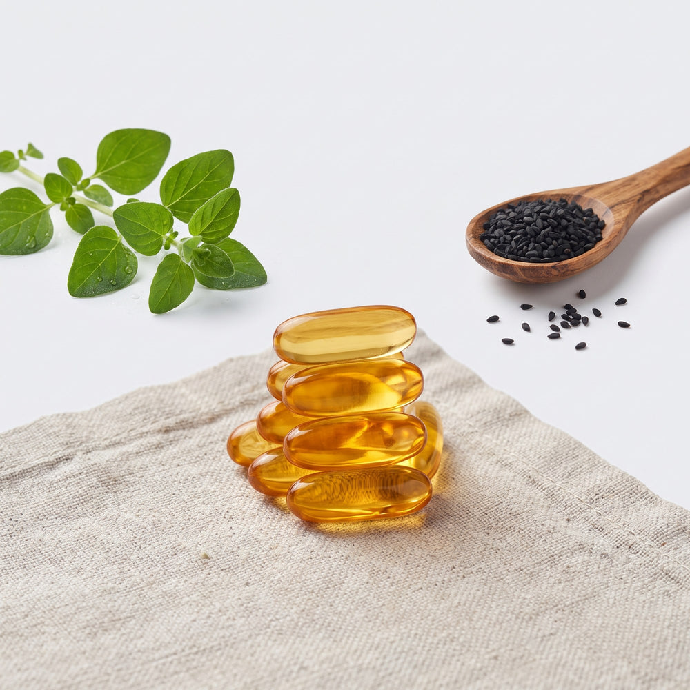 Oregano leaves, black seeds and a stack of softgels