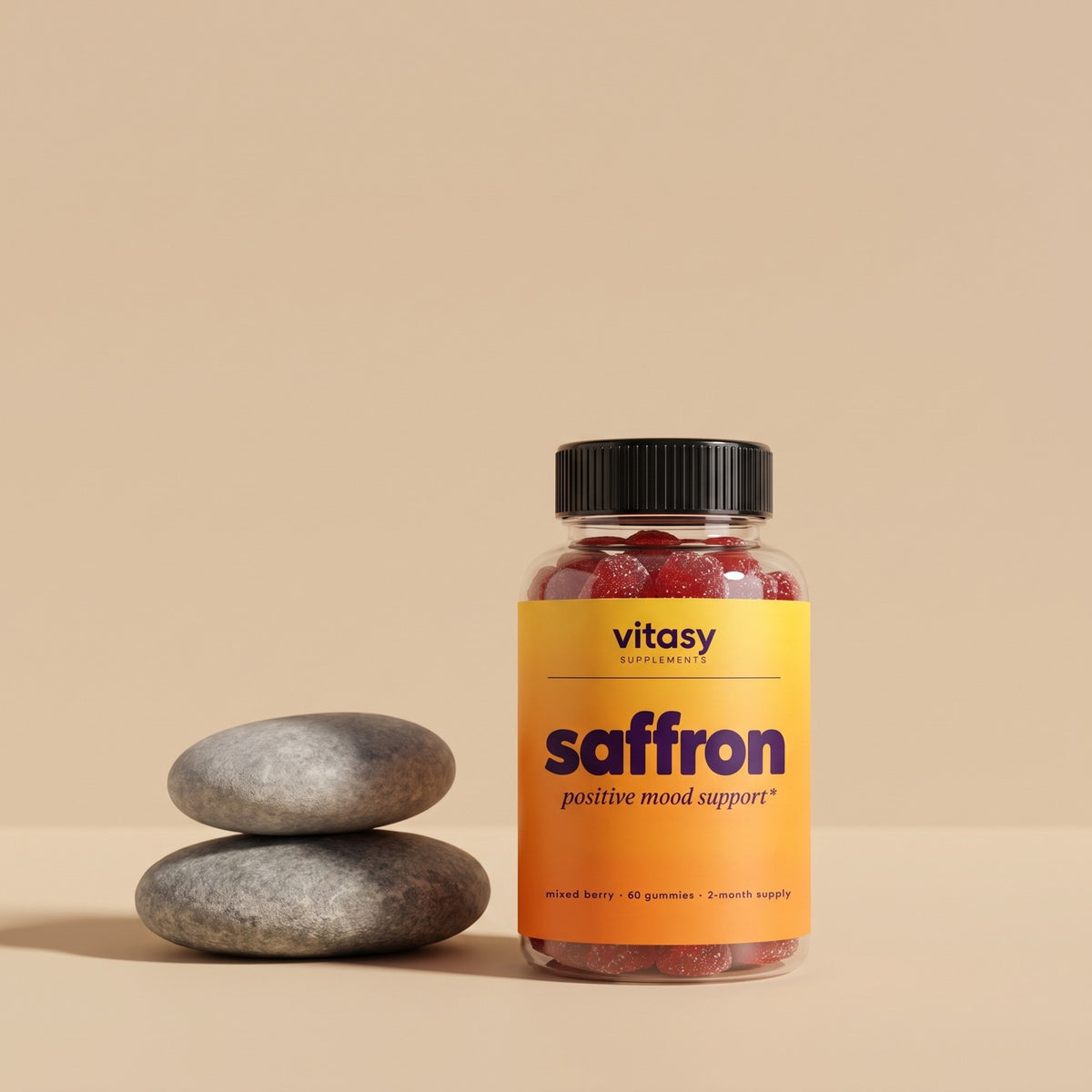 Vitasy Saffron Gummies bottle next to stacked smooth stones