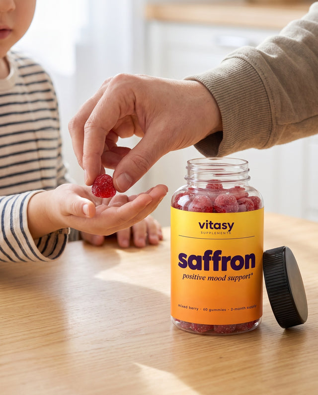 Parent handing a child one berry gummy next to the Vitasy Saffron Gummies jar