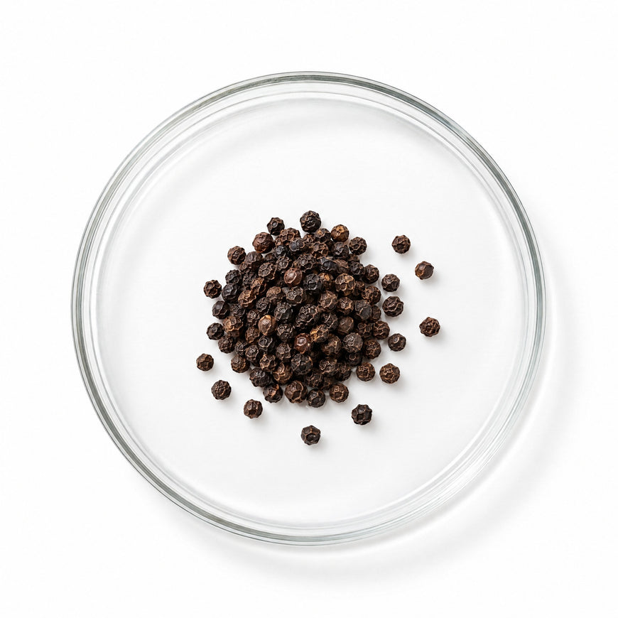 Whole black peppercorns, the source of BioPerine®, in a glass dish