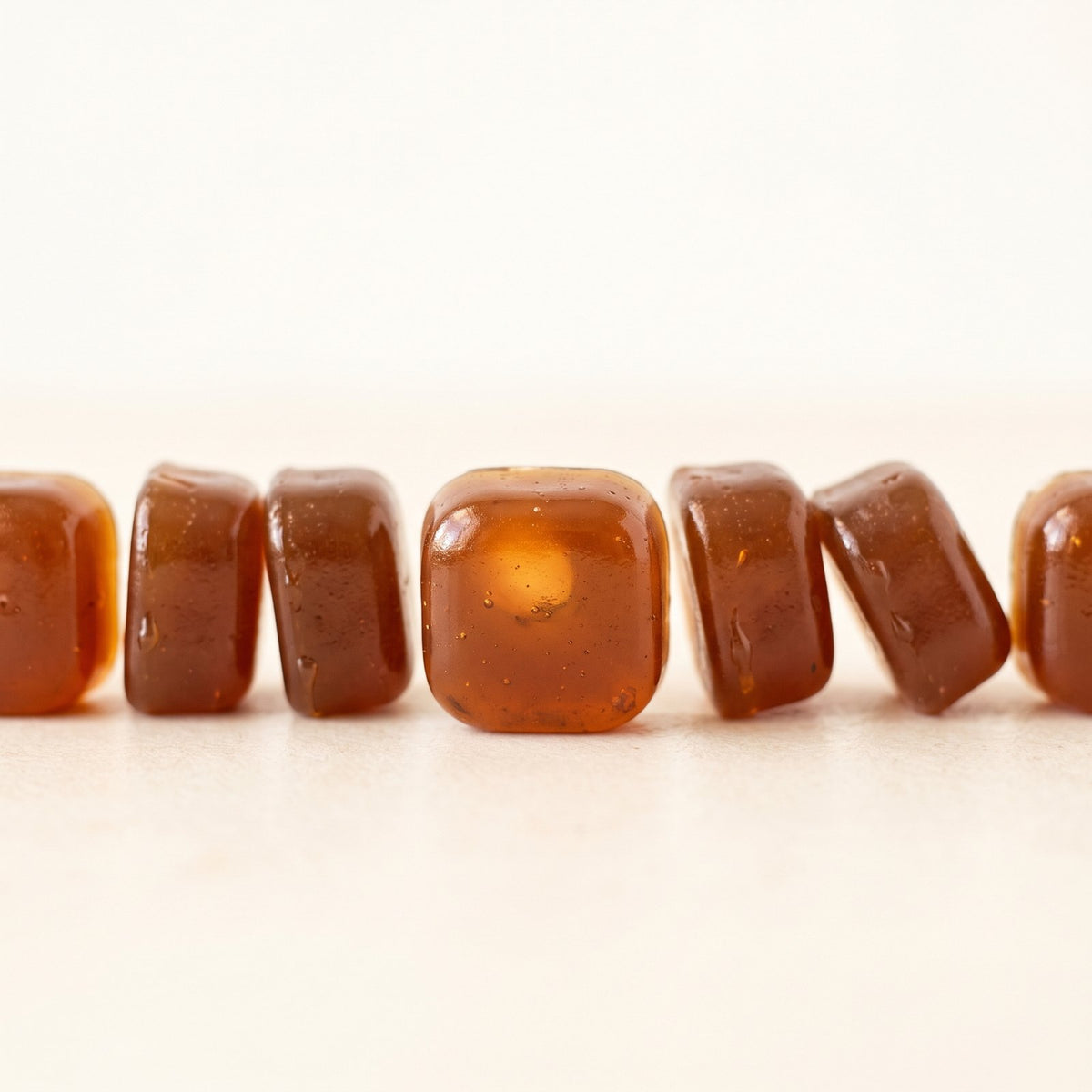 Row of glossy amber gummies