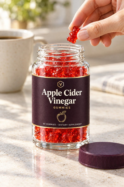 Taking a gummy from an open jar of Vitasy Apple Cider Vinegar Gummies