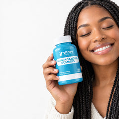 Smiling woman holding a bottle of Vitasy Ashwagandha Gummies