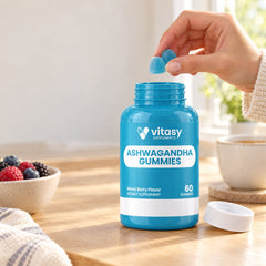 Taking two gummies from an open bottle of Vitasy Ashwagandha Gummies