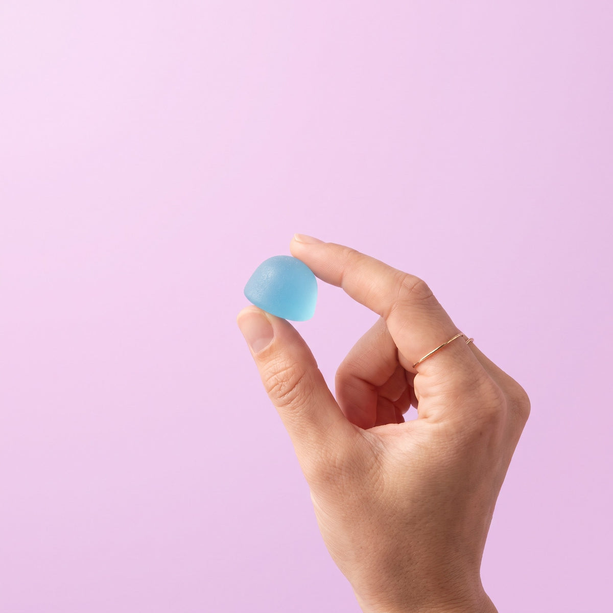 Hand holding one blue gummy