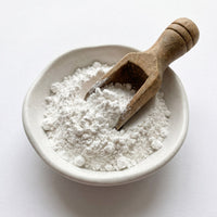 Bowl of white powder with a wooden scoop