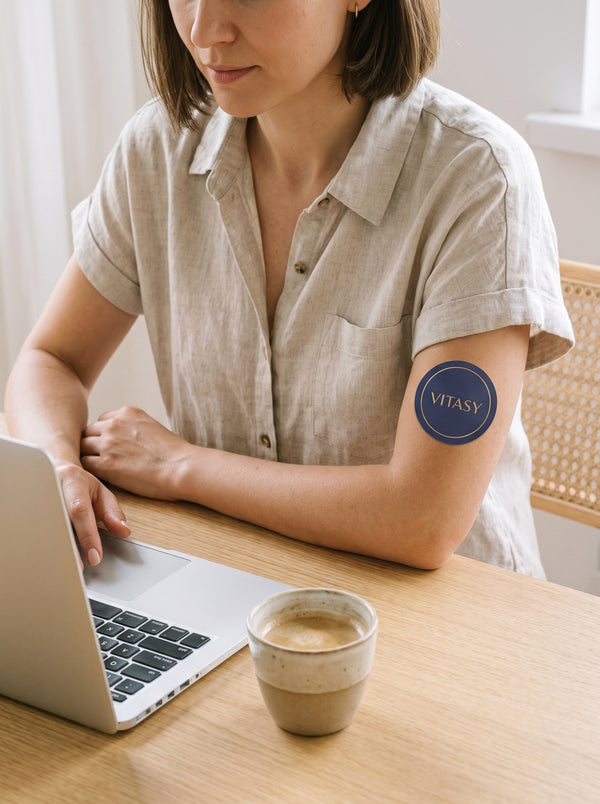 Woman at a desk wearing a patch on her upper arm