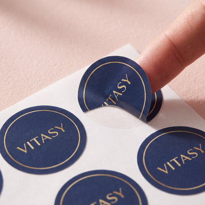 Close-up of round navy Vitasy patches on their backing sheet