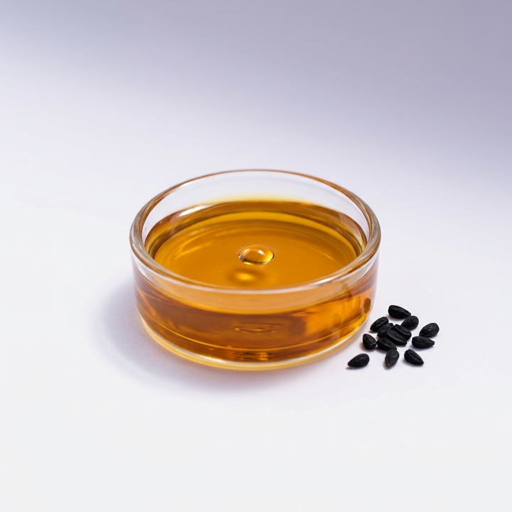 Black seed oil in a glass dish with nigella sativa seeds