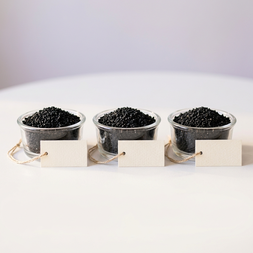 Three identical dishes of black seeds with blank unlabeled tags