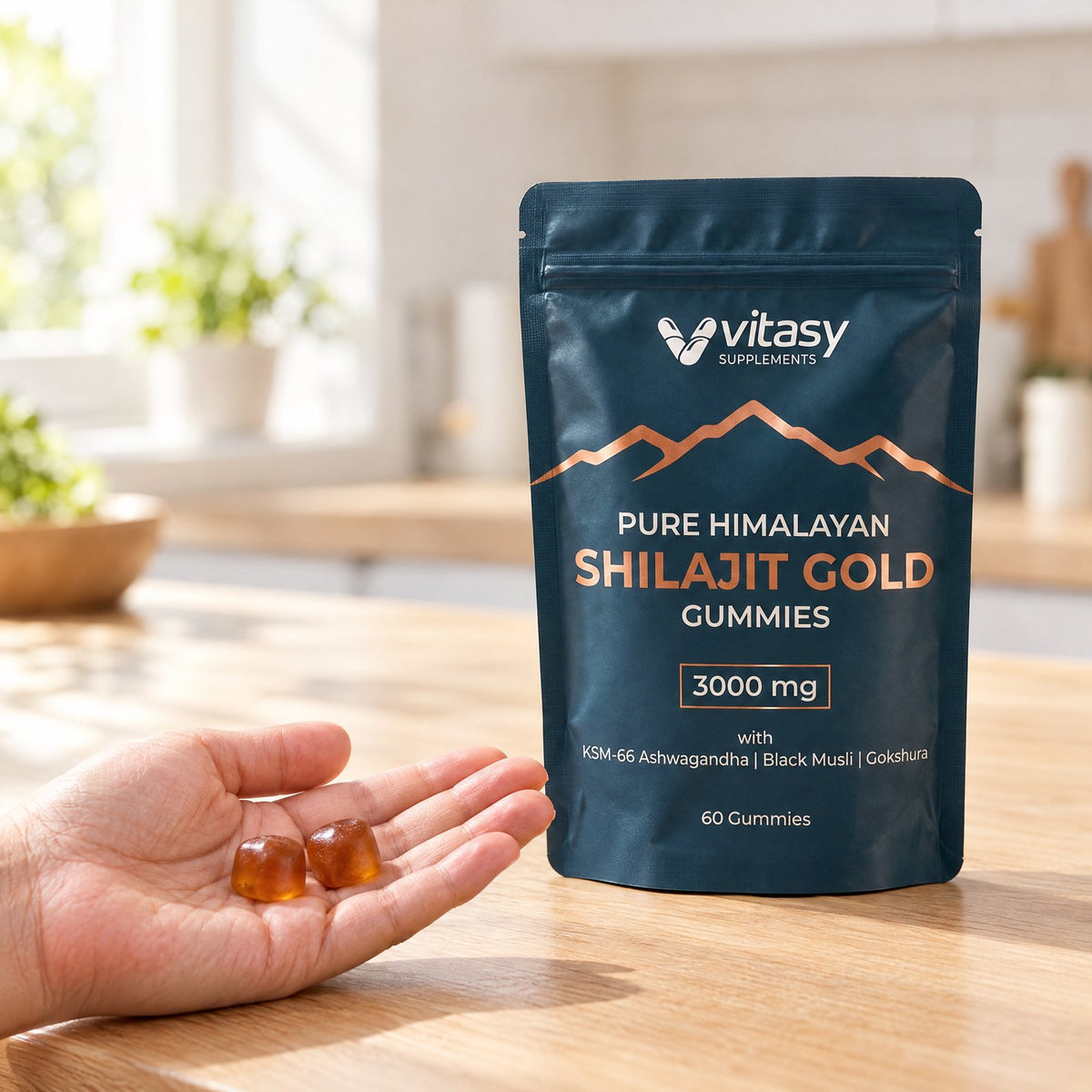 Two shilajit gummies in an open palm next to the pouch