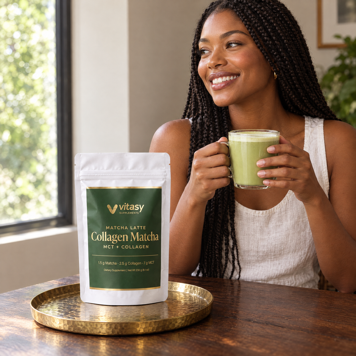Woman enjoying a matcha latte with the pouch on a brass tray