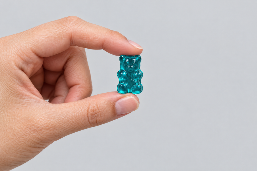 Hand holding a creatine gummy bear