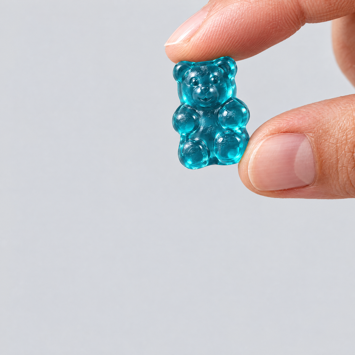Creatine in gummy form, held between two fingers