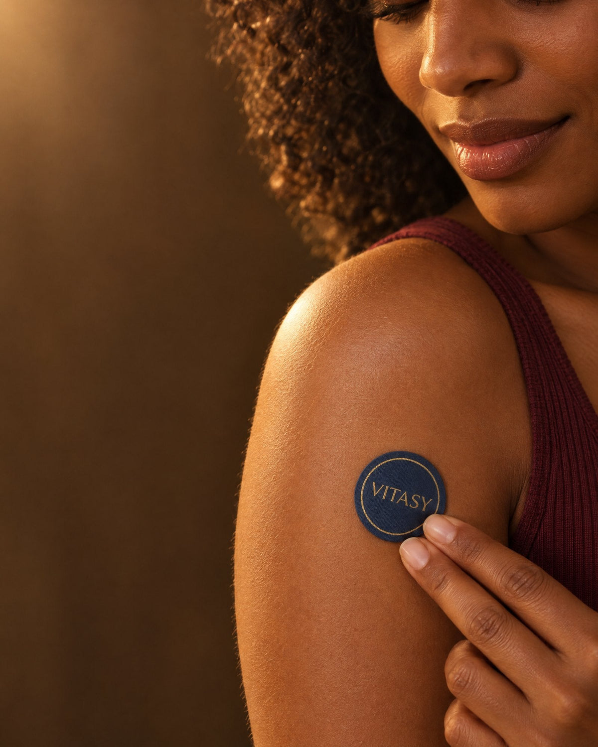 Woman applying a Vitasy energy patch to her shoulder