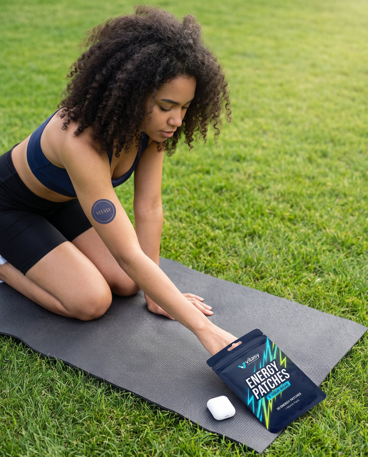 Woman on a yoga mat outdoors wearing a Vitasy energy patch