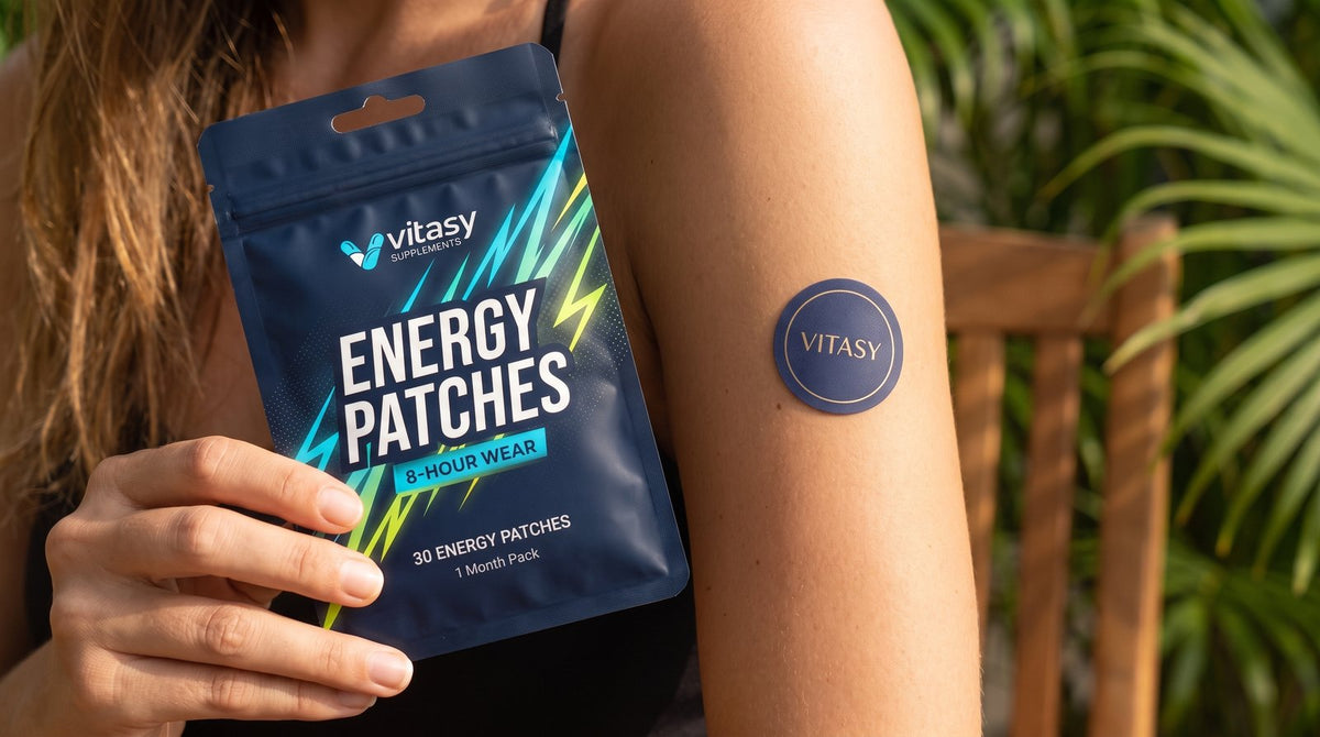 Woman holding Vitasy Energy Patches with a patch on her arm