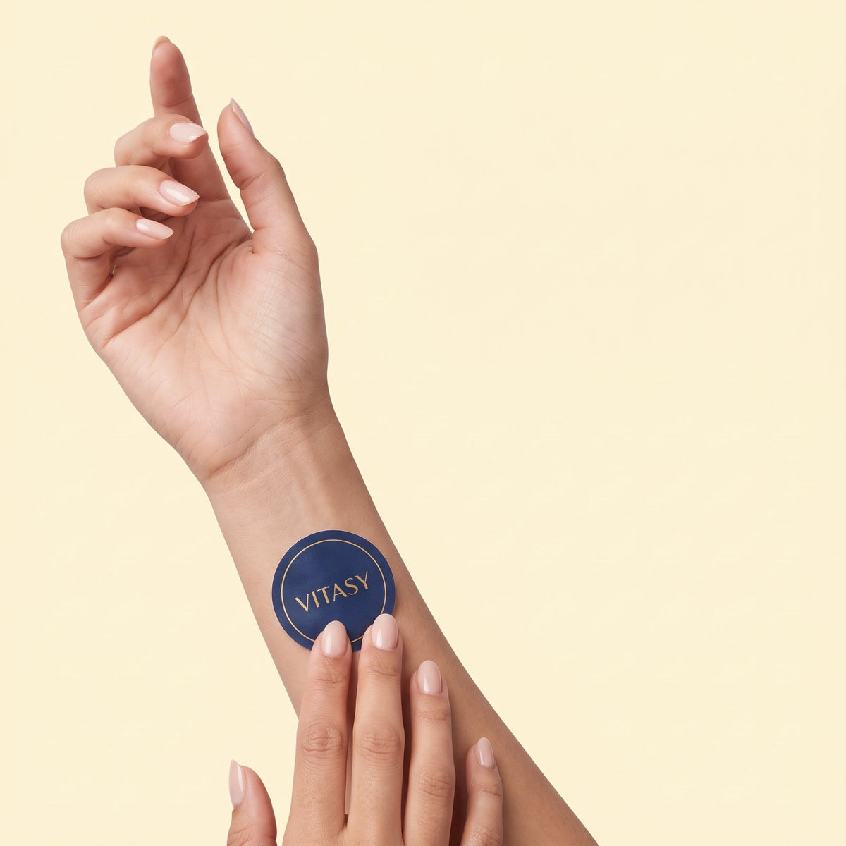 Hand applying a navy Vitasy energy patch to the inner forearm