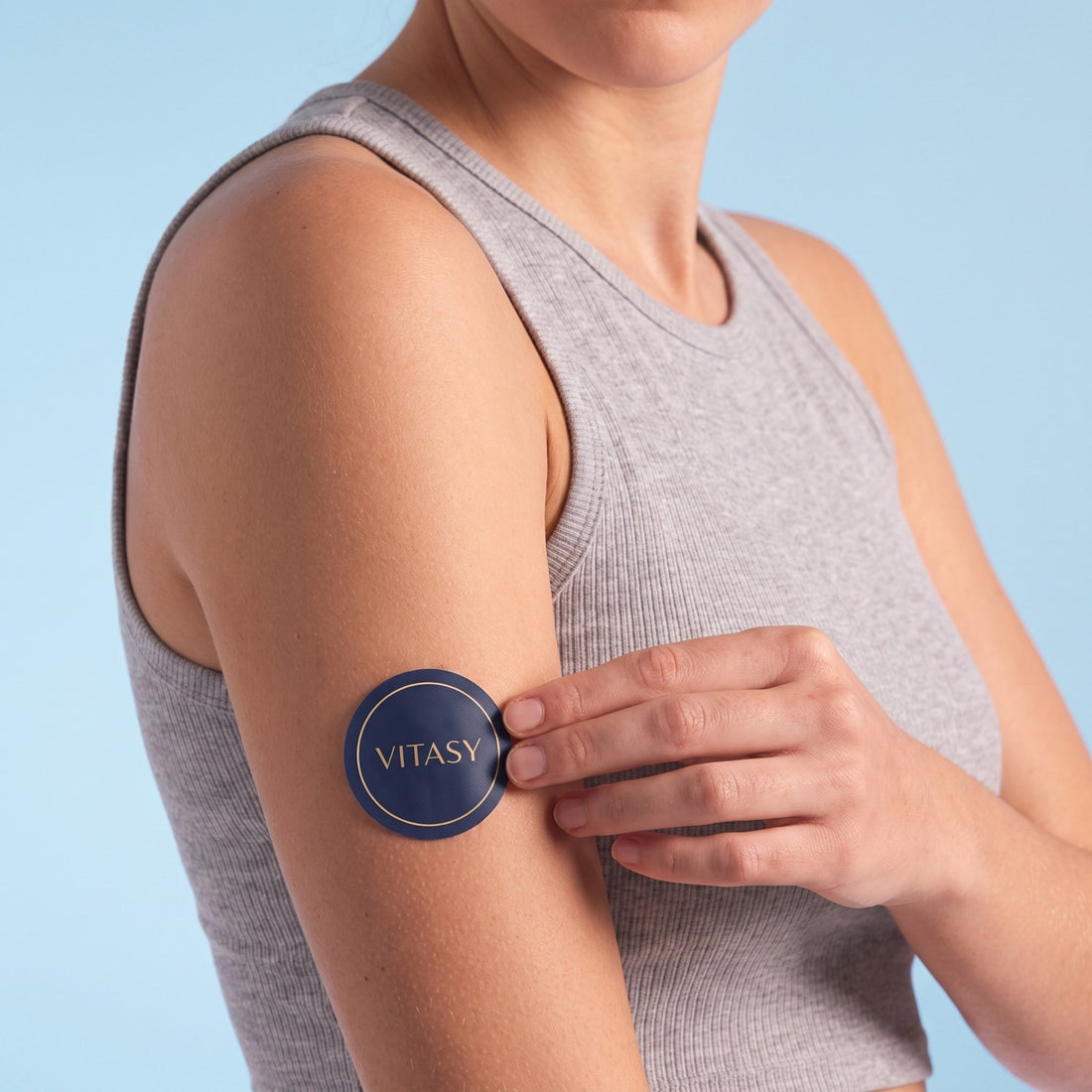 Woman applying an Energy Patch to her upper arm