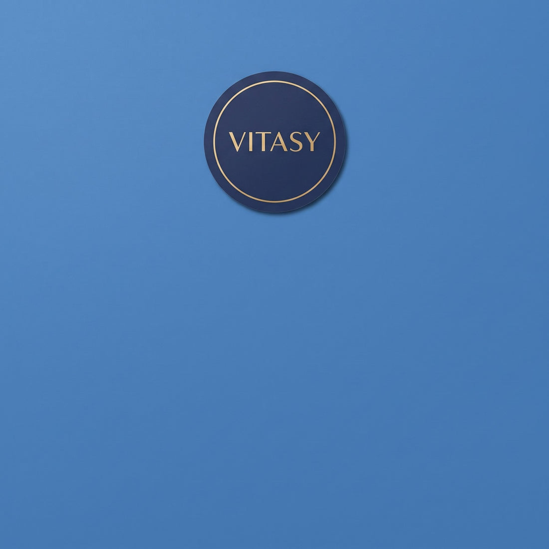 Round navy Vitasy patch on a light blue background
