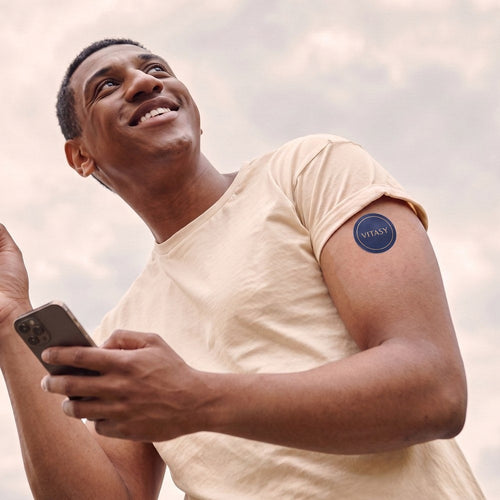 Man outdoors wearing a Vitasy patch on his upper arm