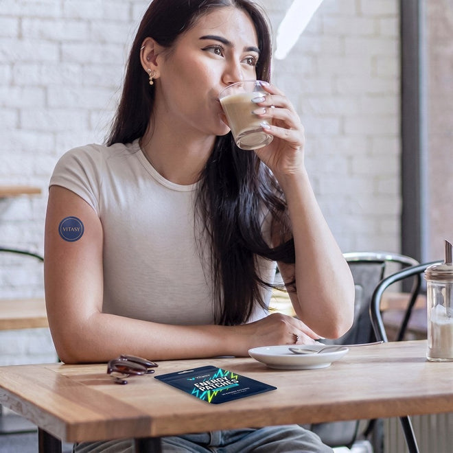 Woman with coffee wearing a Vitasy patch on her upper arm