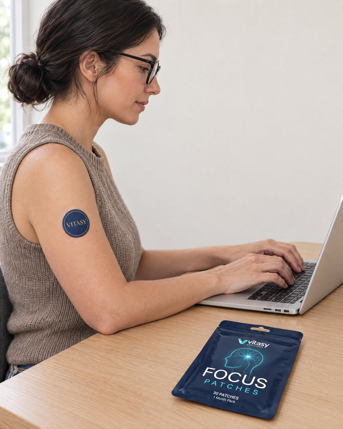 Woman working on a laptop wearing a Vitasy patch