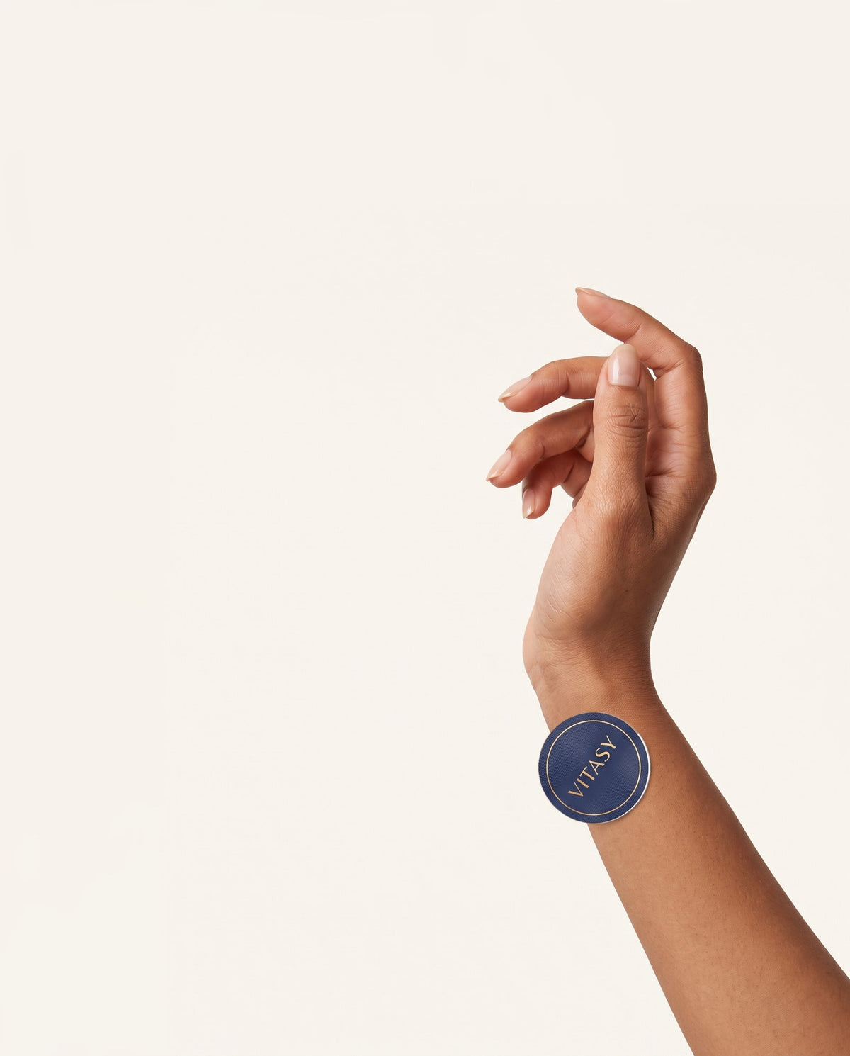 Hand with a Vitasy focus patch on the wrist