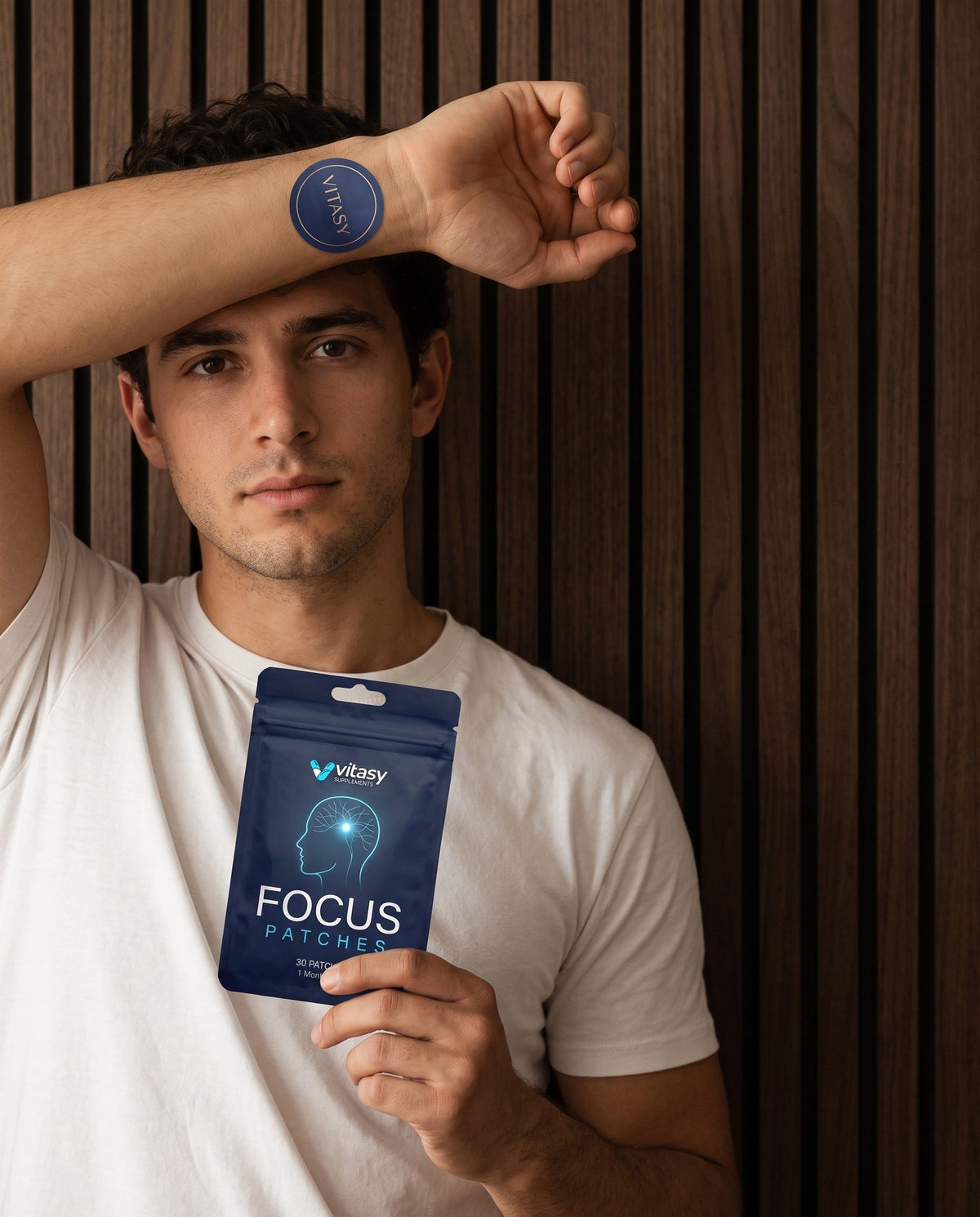 Man wearing a Vitasy focus patch on his wrist, holding the pouch