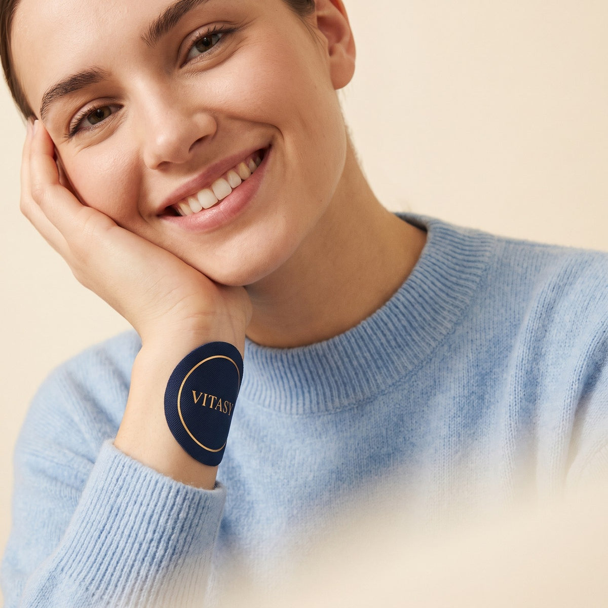 Smiling woman wearing a navy Vitasy patch on her wrist