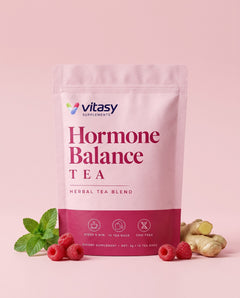 Vitasy herbal tea pouch on a pink background with raspberries, spearmint and ginger root