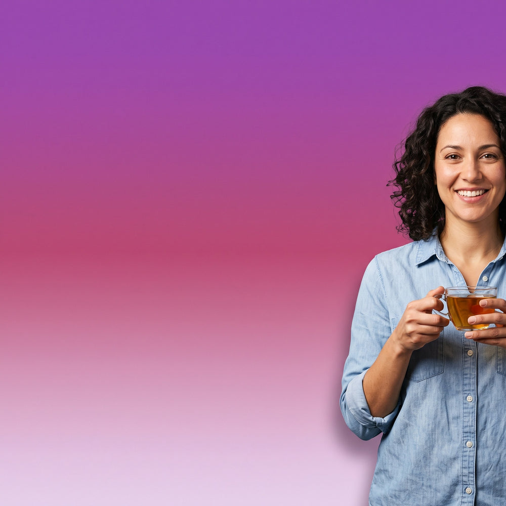 Smiling woman holding a glass cup of herbal tea