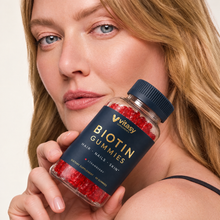 Woman holding a bottle of Vitasy Biotin Gummies Strawberry