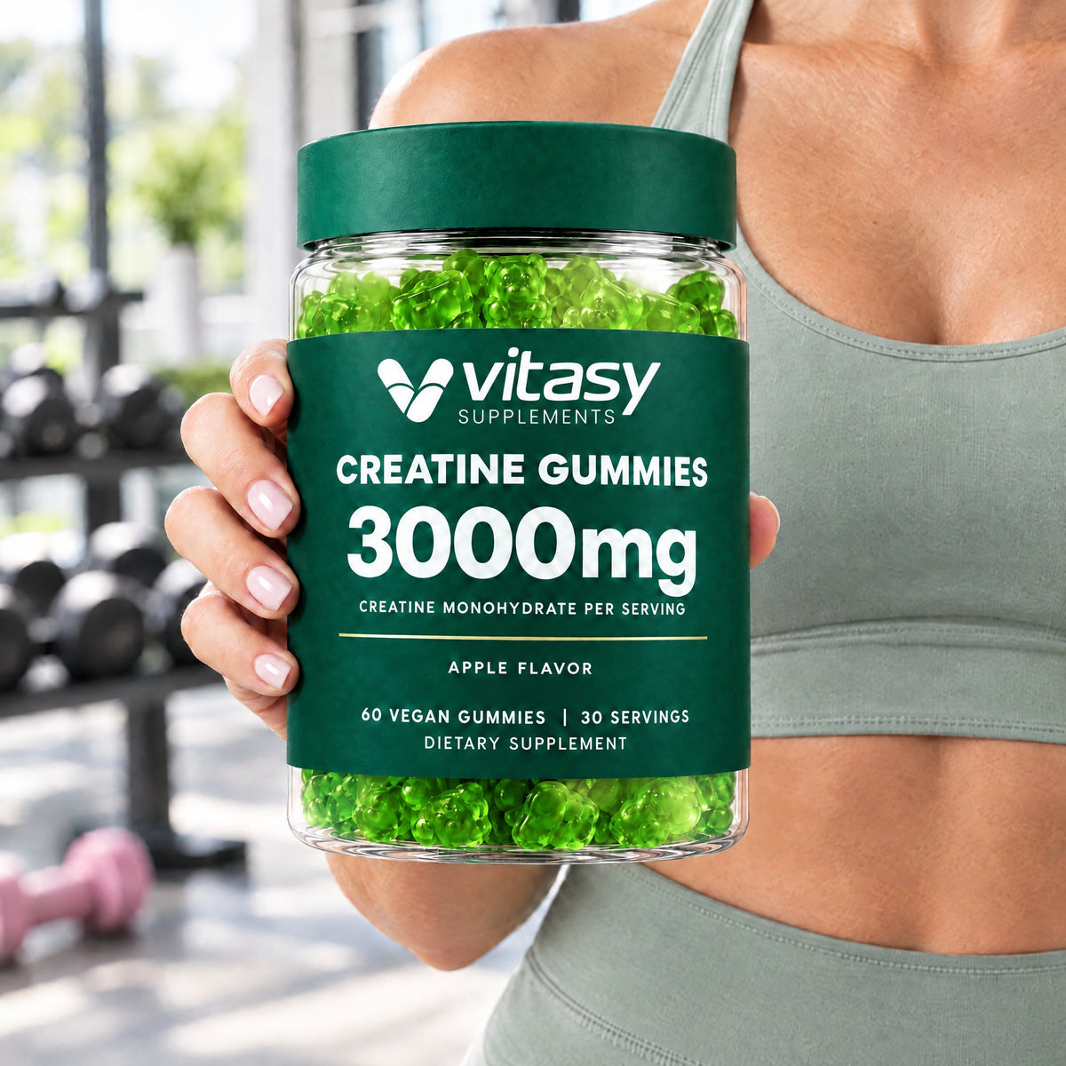 Woman in a gym holding a jar of apple Vitasy Creatine Gummies